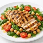 Refeição proteica completa com frango grelhado, grão-de-bico e vegetais frescos.